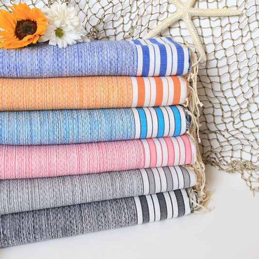 Stack of colorful towels with a starfish and sunflower against a textured net background